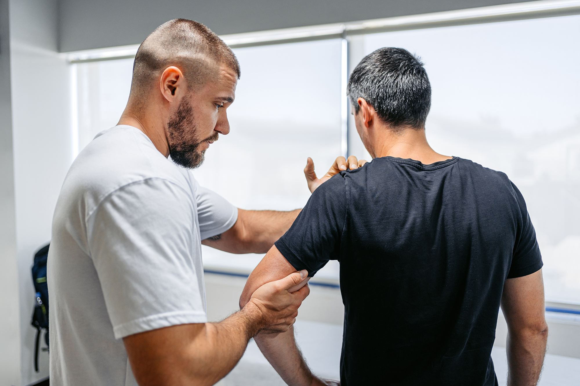 Physical Therapist Adjusting His Male Client's Arm In His Office